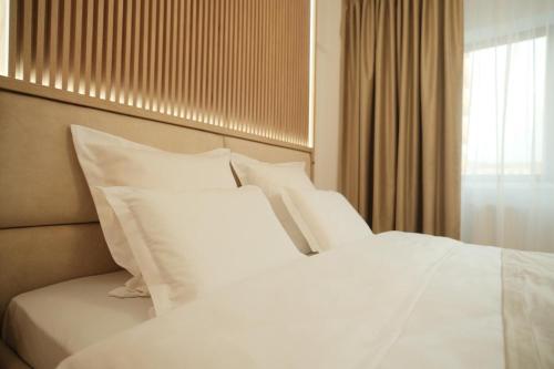 2 białe poduszki na łóżku w pokoju w obiekcie Green Studio w mieście Târgu Neamț