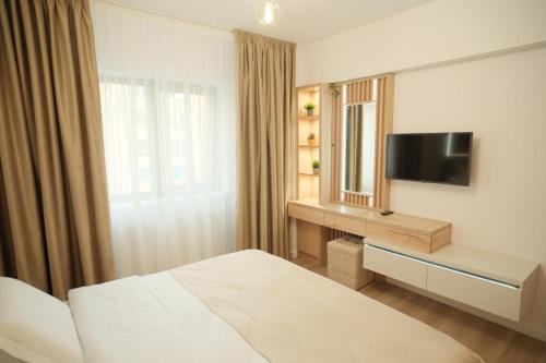 a hotel room with a bed and a television at Green Studio in Tîrgu Neamţ