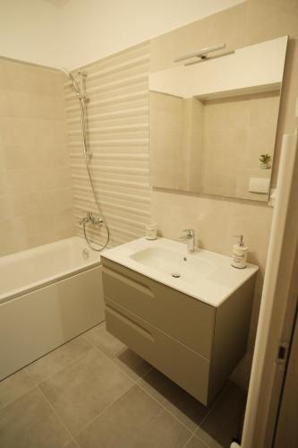 a bathroom with a sink and a tub and a mirror at Green Studio in Târgu Neamț