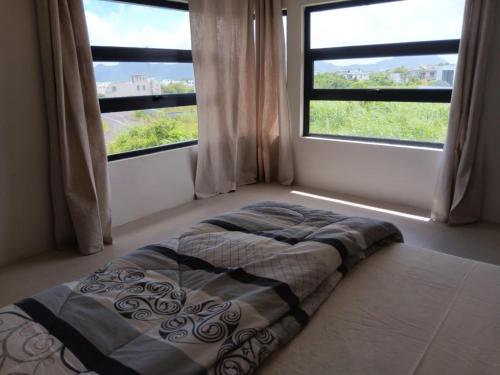 a bed sitting in a room with a window at Palms Haven - Mauritius - Modern and luxury vacation home in Phoenix
