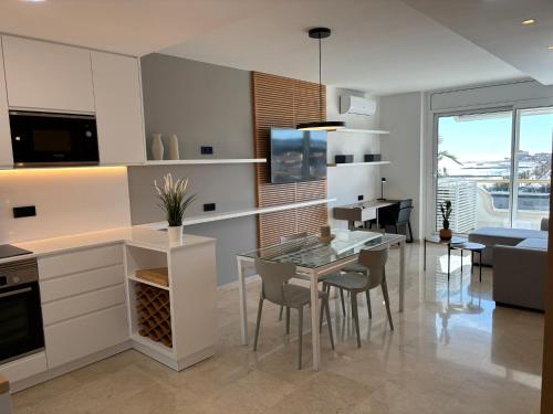 a kitchen with a glass table and a dining room at Mediterraneo Sitges in Sitges