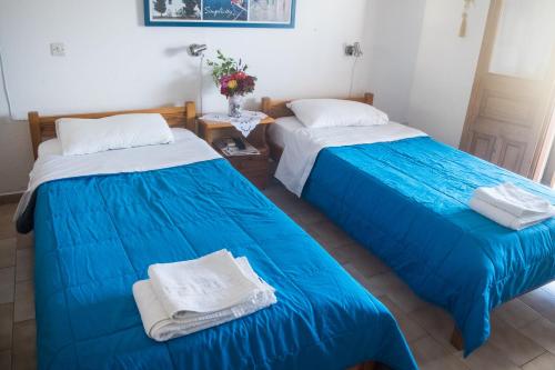 two beds sitting next to each other in a room at Yvonni Studios in Patmos