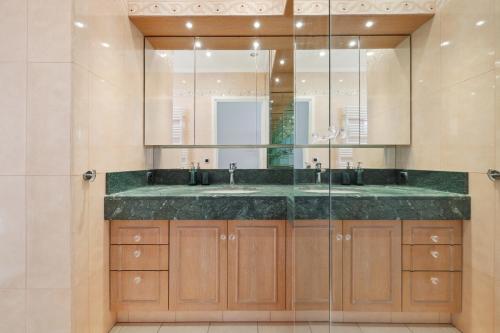 a bathroom with a sink and a glass shower at Escapade à Monaco, appartement vue mer et plage in Saint-Antoine