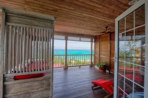 a room with a balcony with a view of the ocean at A Stone's Throw Away in Nassau