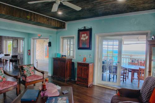 sala de estar con paredes azules, mesa y sillas en A Stone's Throw Away en Nassau