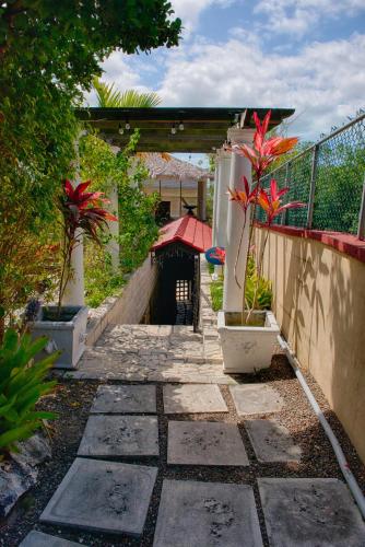 a garden with a stone walkway with potted plants at A Stone's Throw Away in Nassau
