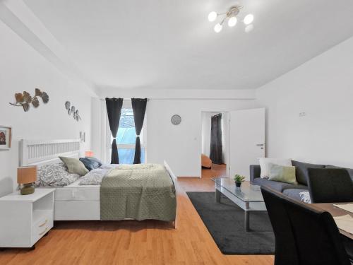 a white living room with a bed and a couch at sparkasse platz 8 in Stockerau