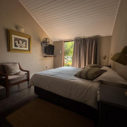 Un dormitorio con una cama grande y una ventana. en Three Thymes Inn, en Tierpoort