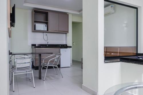 een keuken met een tafel en stoelen in een kamer bij Pousada Refugio Costeiro in Bombinhas