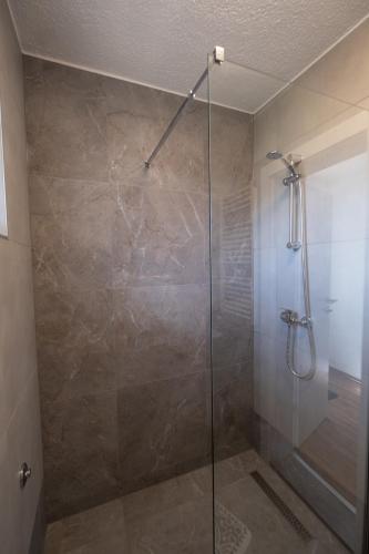 a shower with a glass door in a bathroom at Studio Apartman Mak in Bihać