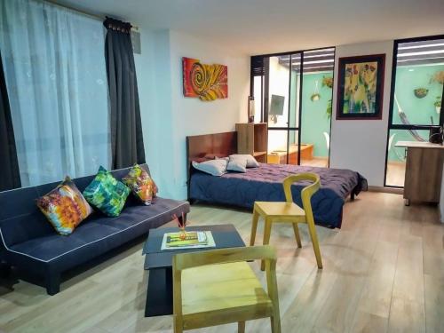 een woonkamer met een bank en een bed bij Hermoso Apartaestudio en el centro histórico in Bogota