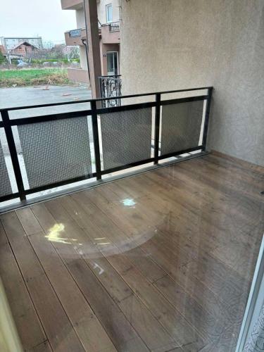 uma varanda com um corrimão de metal e um piso de madeira em Ivet Apartmets em Ledine