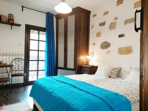 a bedroom with a bed with a blue blanket at Golden Horn Guest House in Iskrets