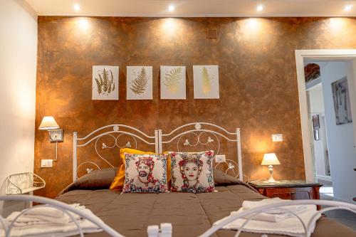 una camera da letto con un letto con opere d'arte sul muro di MonteVergine Domus a Catania