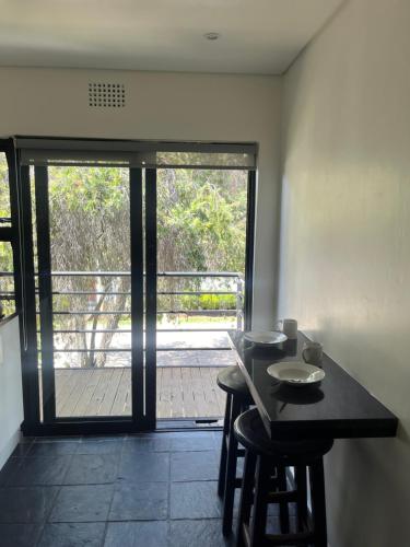 a kitchen with a table and stools and a sliding glass door at Vetho 1 Apartments OR Tambo Airport in Johannesburg
