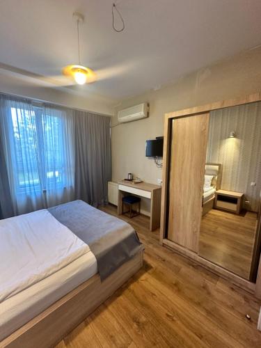 a hotel room with a large bed and a desk at Marotel in Tbilisi City
