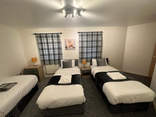 pokój z 3 łóżkami w pokoju w obiekcie City Airport Apartment w mieście Wythenshawe