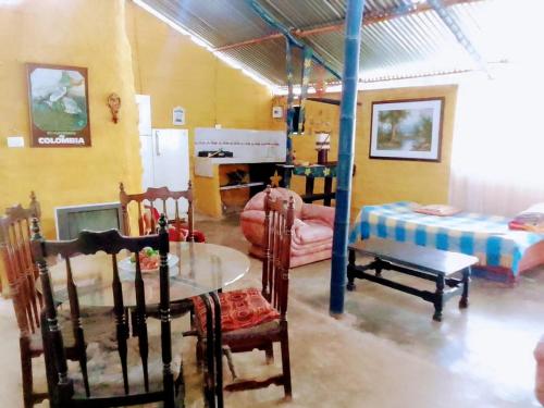 Hostal Colina de San Antonio في Jamundí: غرفة معيشة مع طاولة وكراسي وسرير