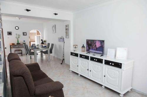 una sala de estar con TV en un centro de entretenimiento blanco en Casa 'Saudade' en Moura