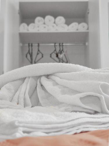 a pile of white towels sitting on a bed at sparkasse platz 8 in Stockerau