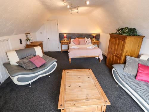 ein Wohnzimmer mit einem Sofa, einem Bett und einem Tisch in der Unterkunft Caxton House in Skegness