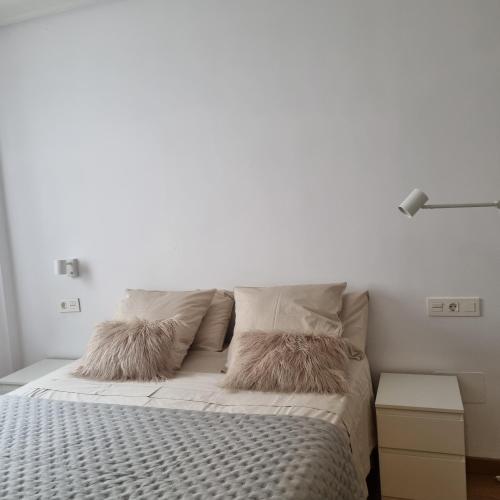 a white bedroom with a bed with two pillows at My Way Catedral in León
