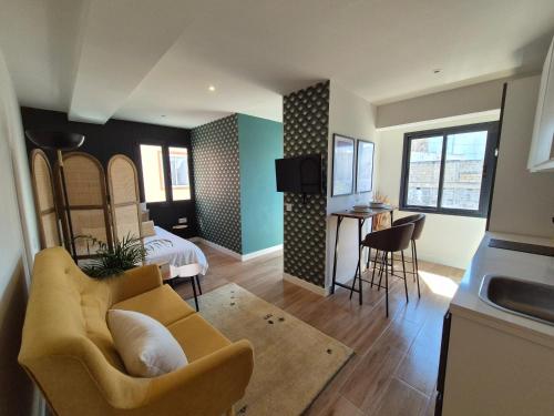 a living room with a couch and a bed and a kitchen at 5 Dragos Suites in La Orotava