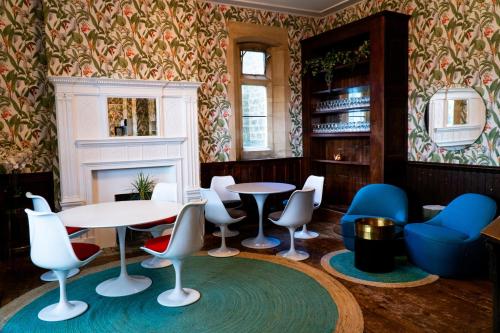 una sala con tavoli, sedie e un camino di 9 Bedrooms Grand Manor House Near Bath, Sleeps 26 a Seend