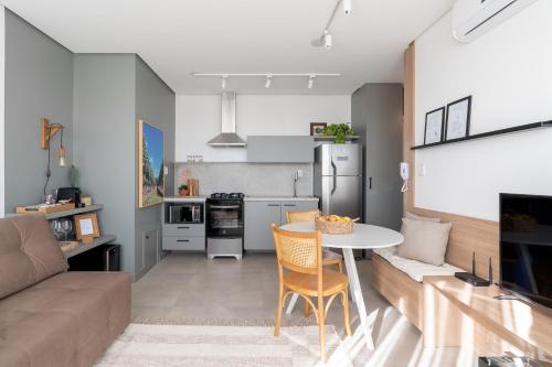 a kitchen and living room with a table and a couch at Apartamento no coração de Bento Gonçalves in Bento Gonçalves