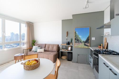 a kitchen and living room with a table and a couch at Apartamento no coração de Bento Gonçalves in Bento Gonçalves