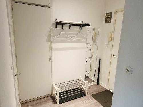 a white closet with a glass door and a shelf at City Apartment in Tampere