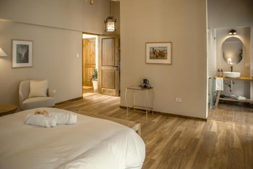 a bedroom with a white bed and a chair at Sierra Sacred Valley in Urubamba