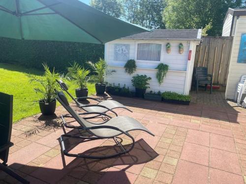 grupa krzeseł i parasol na patio w obiekcie Luxe chalet in prachtig natuurgebied w mieście Lith