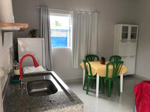 uma cozinha com uma mesa e cadeiras verdes numa cozinha em Residencial Jasmim em Palmas