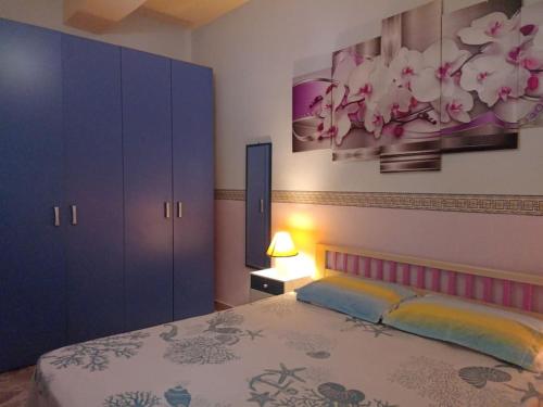 - une chambre avec un lit et une peinture murale dans l'établissement Siculiana Marina - oasi wwf, à Siculiana Marina