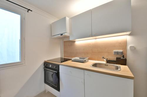 une cuisine avec un évier et une cuisinière dans l'établissement Confortable appartment near Stade de France, à Saint-Denis