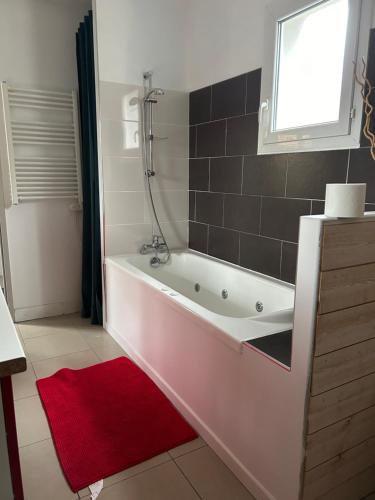 W łazience znajduje się wanna z czerwonym dywanem. w obiekcie Wilo Gujan w mieście Gujan-Mestras
