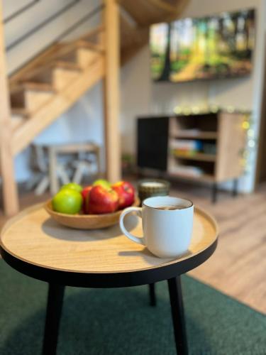 eine Tasse Kaffee und eine Schale Obst auf dem Tisch in der Unterkunft Na Kamieńcu domki in Rzyki