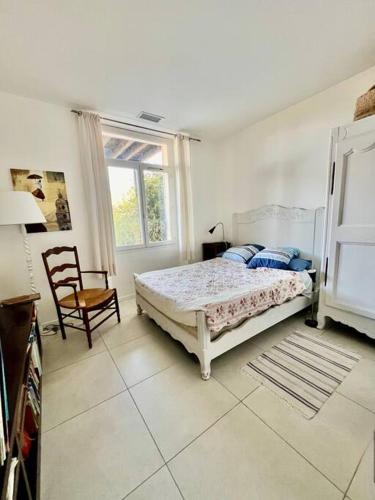 ein Schlafzimmer mit einem Bett, einem Stuhl und einem Fenster in der Unterkunft Villa Lilou*50m de la plage in Le Pradet