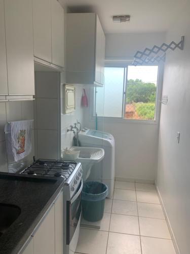 una cocina con estufa horno superior al lado de un fregadero en Perfeito, Apt completo no Centro Político, en Cuiabá
