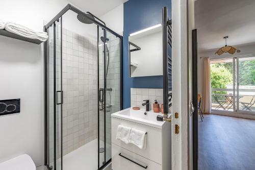 La salle de bains est pourvue d'une douche et d'un lavabo blanc. dans l'établissement Studio rénové avec balcon près des Champs-Elysées, à Paris