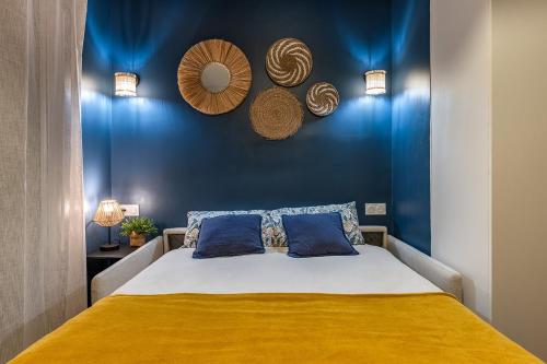 une chambre avec un lit avec un mur bleu dans l'établissement Studio rénové avec balcon près des Champs-Elysées, à Paris