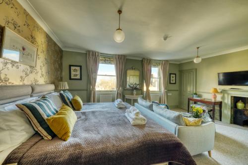a bedroom with a large bed and a couch at Hill House in Bath