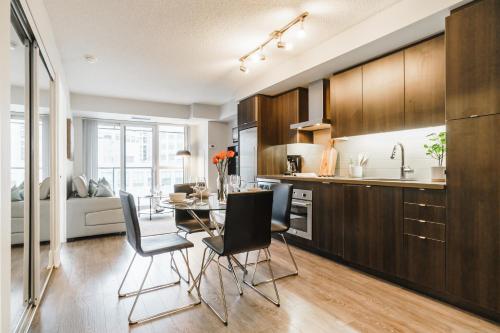 a kitchen and dining room with a table and chairs at Jarvis Suites in Toronto