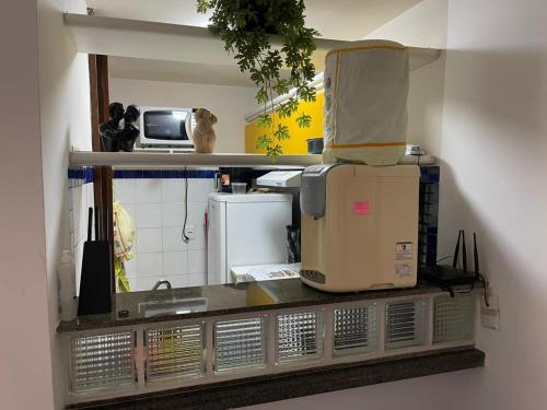 a kitchen with a counter top with a microwave at EDIFÍCIO METROPOLE ONDINA in Salvador