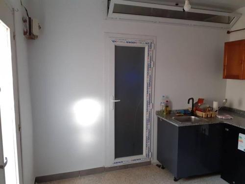 una cocina con una puerta en la esquina de una habitación en superbe appartement en Saoula