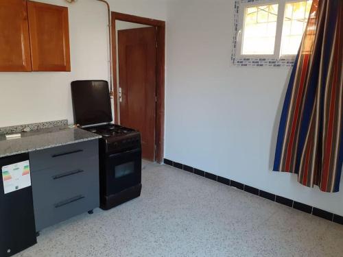 an empty kitchen with a stove and a window at superbe appartement in Saoula