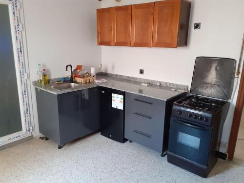 a small kitchen with a stove and a sink at superbe appartement in Saoula