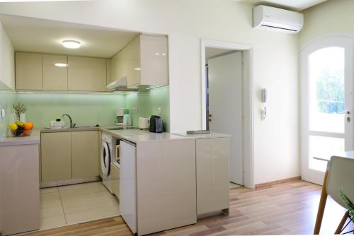 a kitchen with white cabinets and a sink at Bellevue Suites in Agios Nikolaos