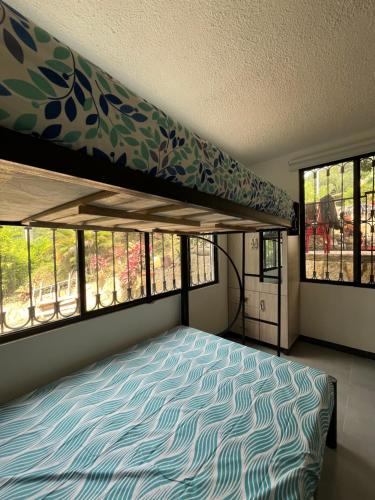 - une chambre avec des lits superposés et des fenêtres dans l'établissement Casa El Guadual, à La Mesa